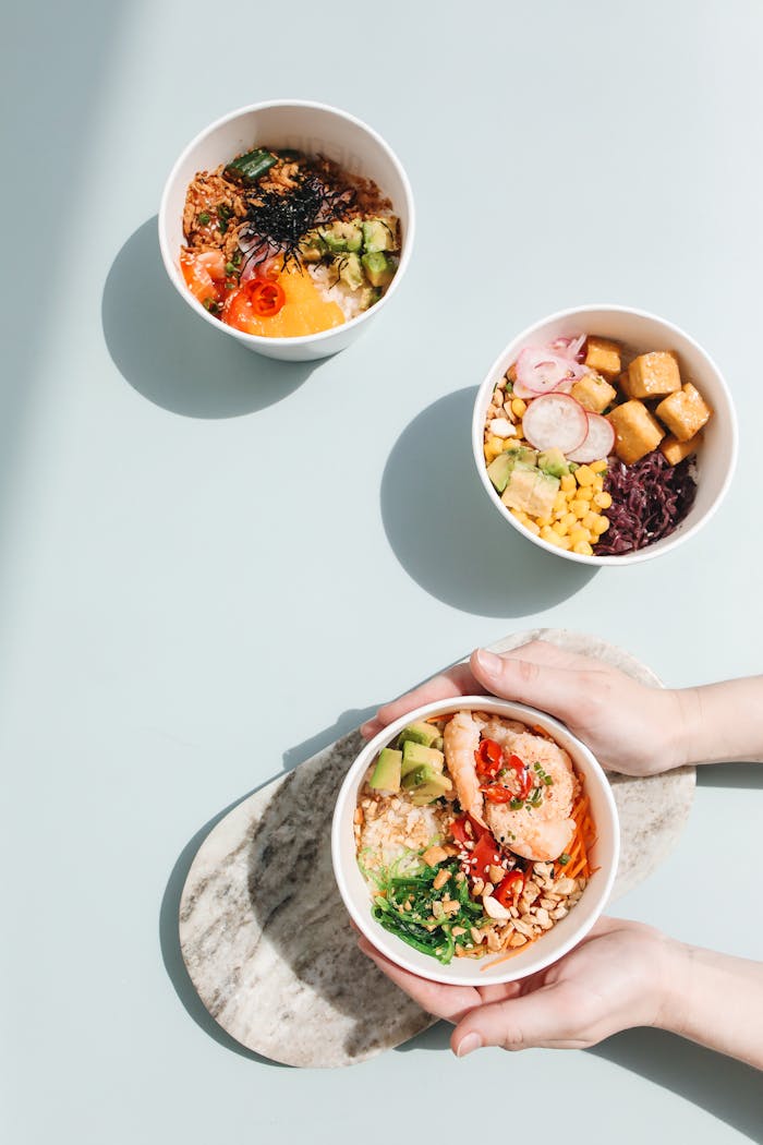 Overhead shot of assorted poke bowls with fresh ingredients like salmon, avocado, and tofu.
